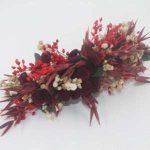 Headdress of preserved flowers in burgundy, beige, red and green tones.