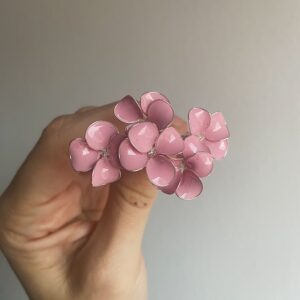 Delicadas horquillas joya con pequeñas flores esmaltadas en tono rosa empolvado. Un diseño romántico y femenino, perfecto para novias que buscan un toque sutil de color en su peinado. Ideales para recogidos suaves, semirecogidos o peinados desenfadados, aportando luz y un acabado elegante sin resultar recargado. También son perfectas para invitadas o eventos especiales. Hechas a mano con mimo, pensadas para realzar peinados de estilo romántico y natural.